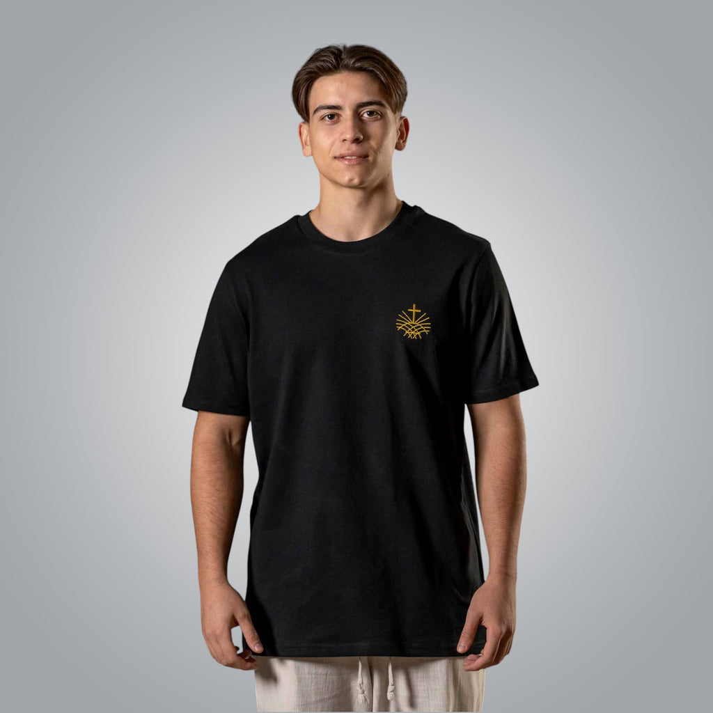 Man wearing black Christian t shirt with gold embroidered Loom in Light logo on the chest