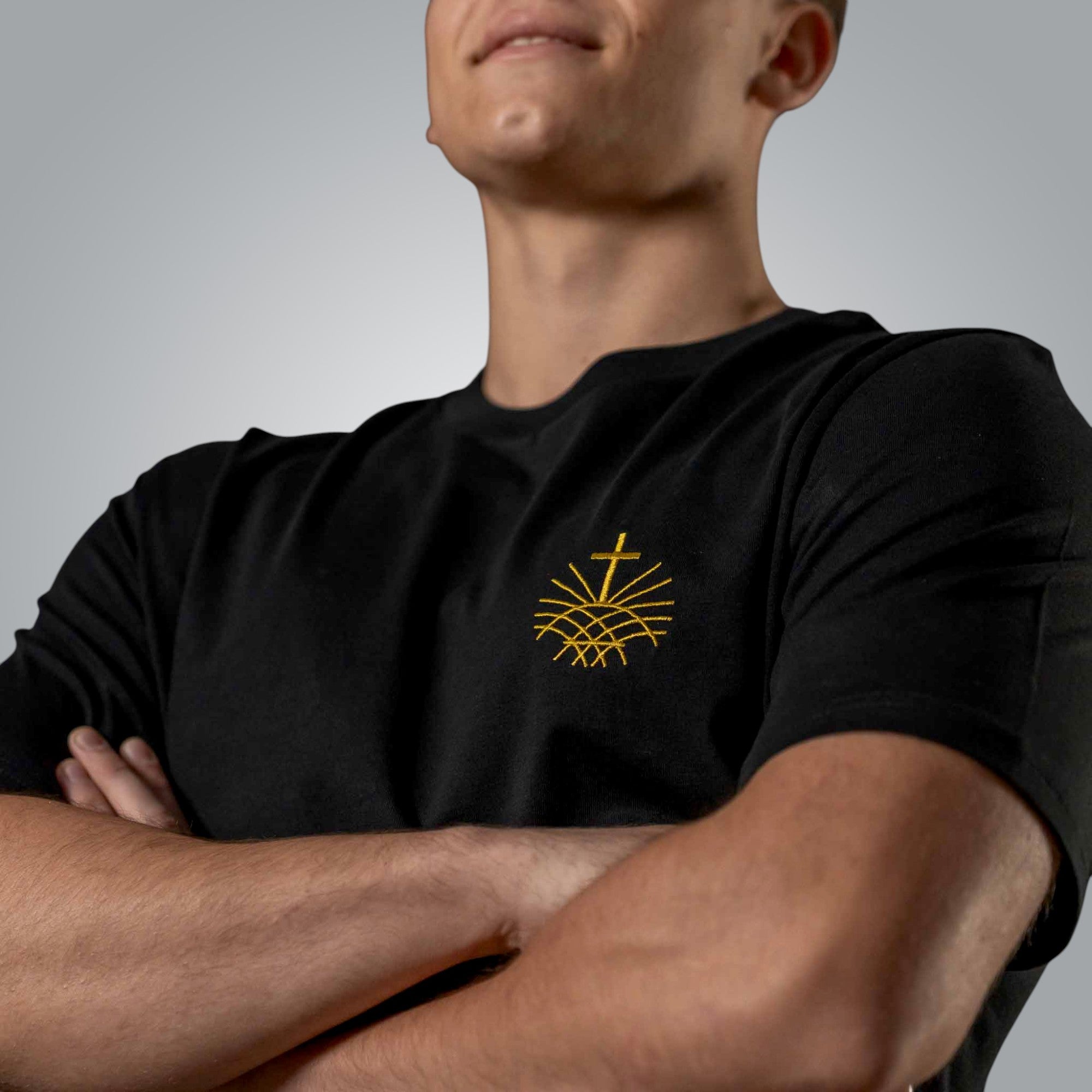 Close up of gold embroidered Loom in Light emblem on black men’s Christian t shirt