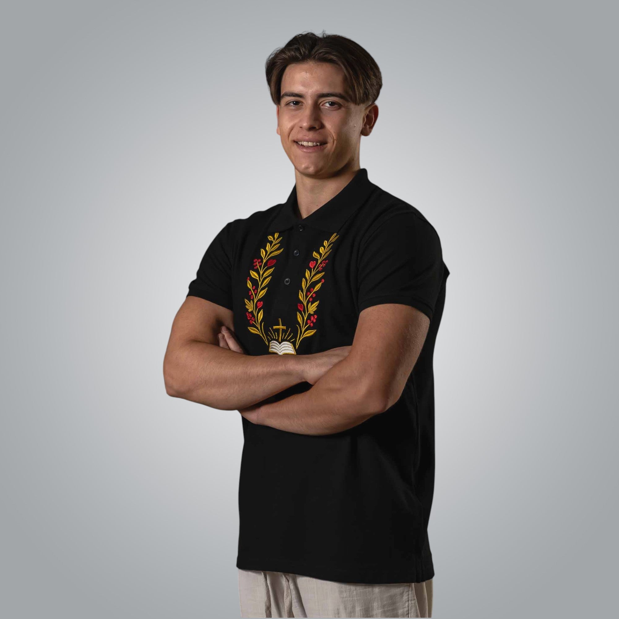 Man wearing black Christian polo with embroidered Bible cross and branches on the chest