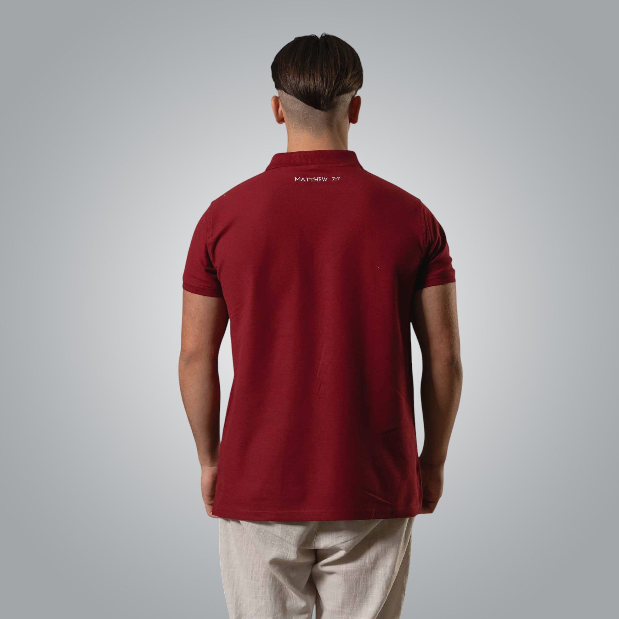 Back of burgundy men’s polo with embroidered Matthew 7:7 verse Ask and it will be given to you