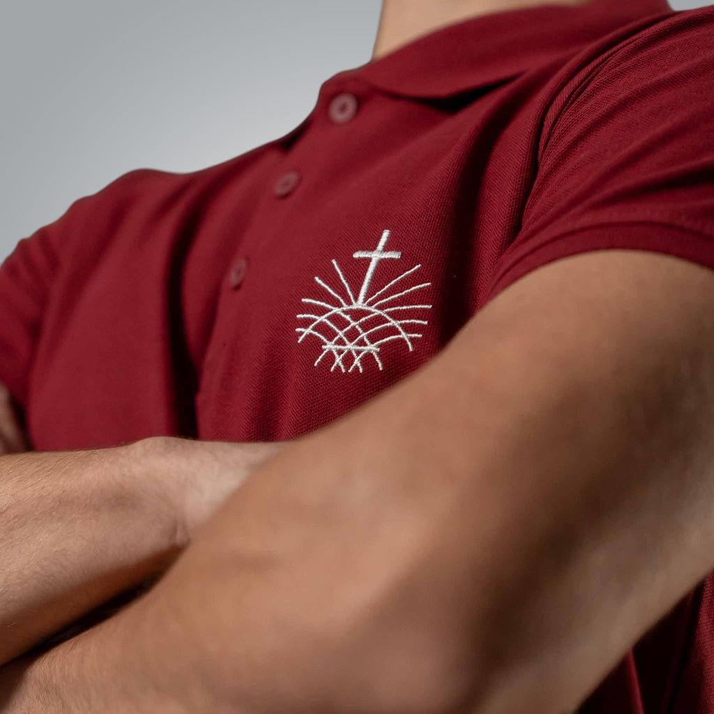 Close up of white embroidered Loom in Light emblem on burgundy men’s Christian polo