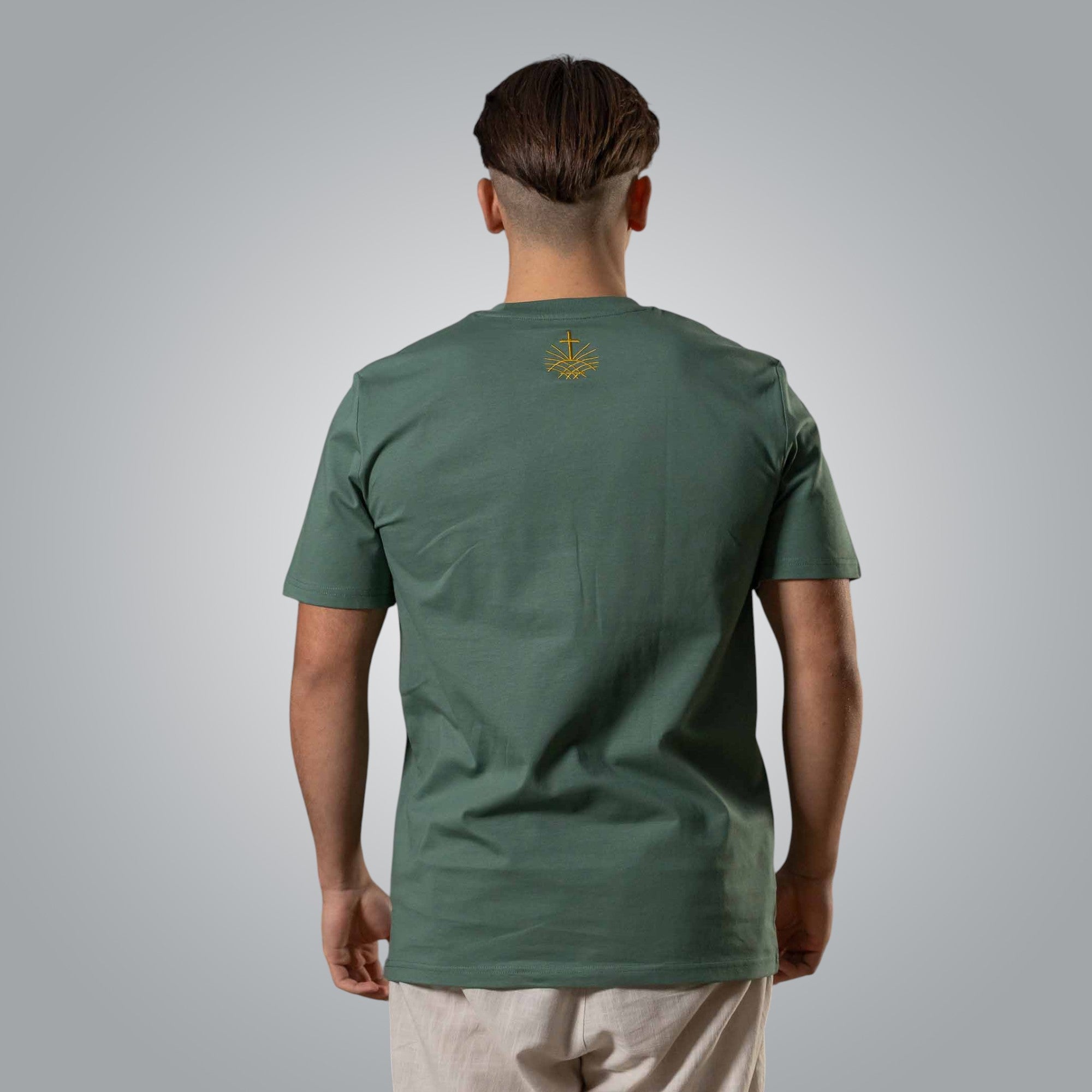 Back view of green men’s t shirt with gold embroidered Loom in Light emblem