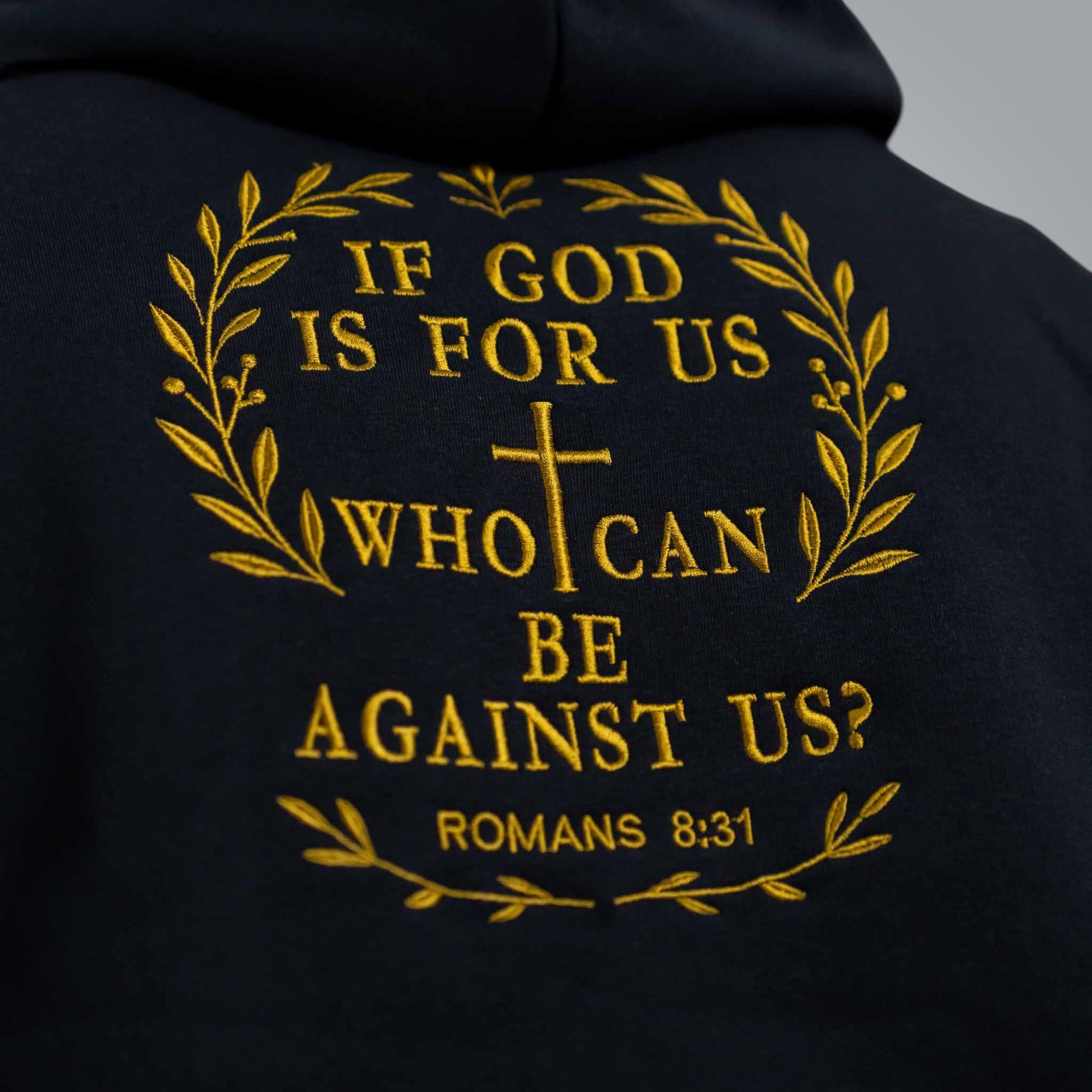 Detail view of gold embroidery on the back with Bible verse Romans 8:31