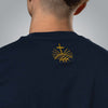 Close up of gold embroidered Loom in Light emblem on back of navy Christian t shirt