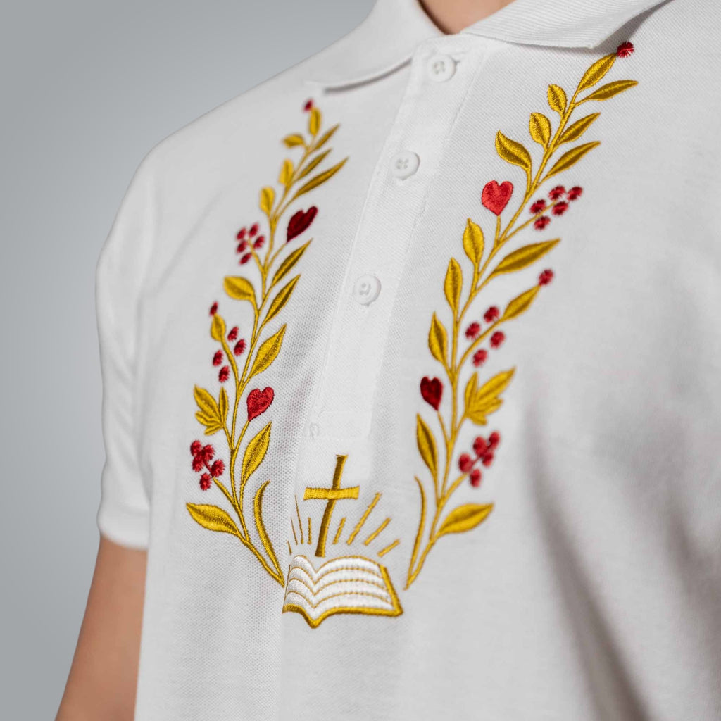 Close up of embroidered Bible cross and branches inspired by John 1:1 on white polo