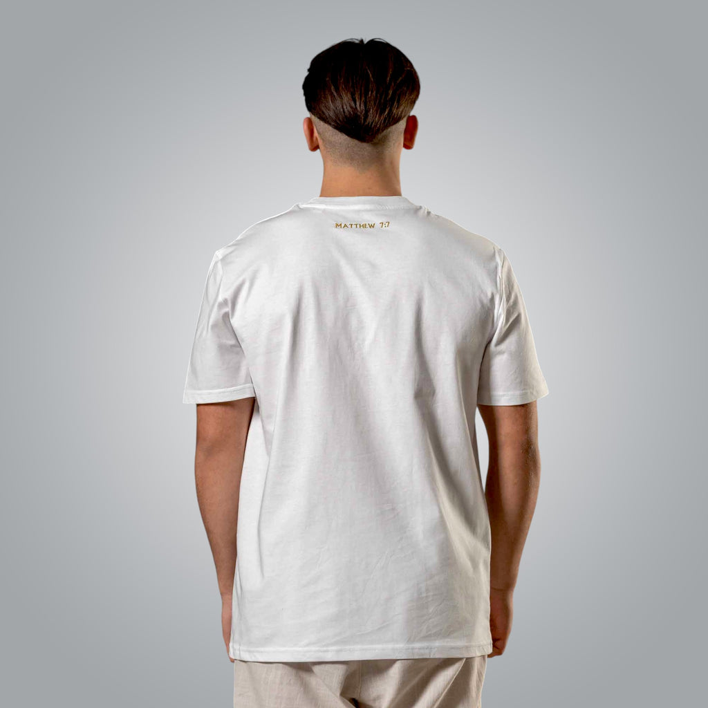 Back view of white men’s t shirt with gold embroidered Matthew 7:7 reference