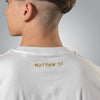 Close up of gold embroidered Matthew 7:7 text on the back of men’s white Christian t shirt
