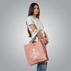 Woman carrying pink tote bag with white embroidered Loom in Light logo