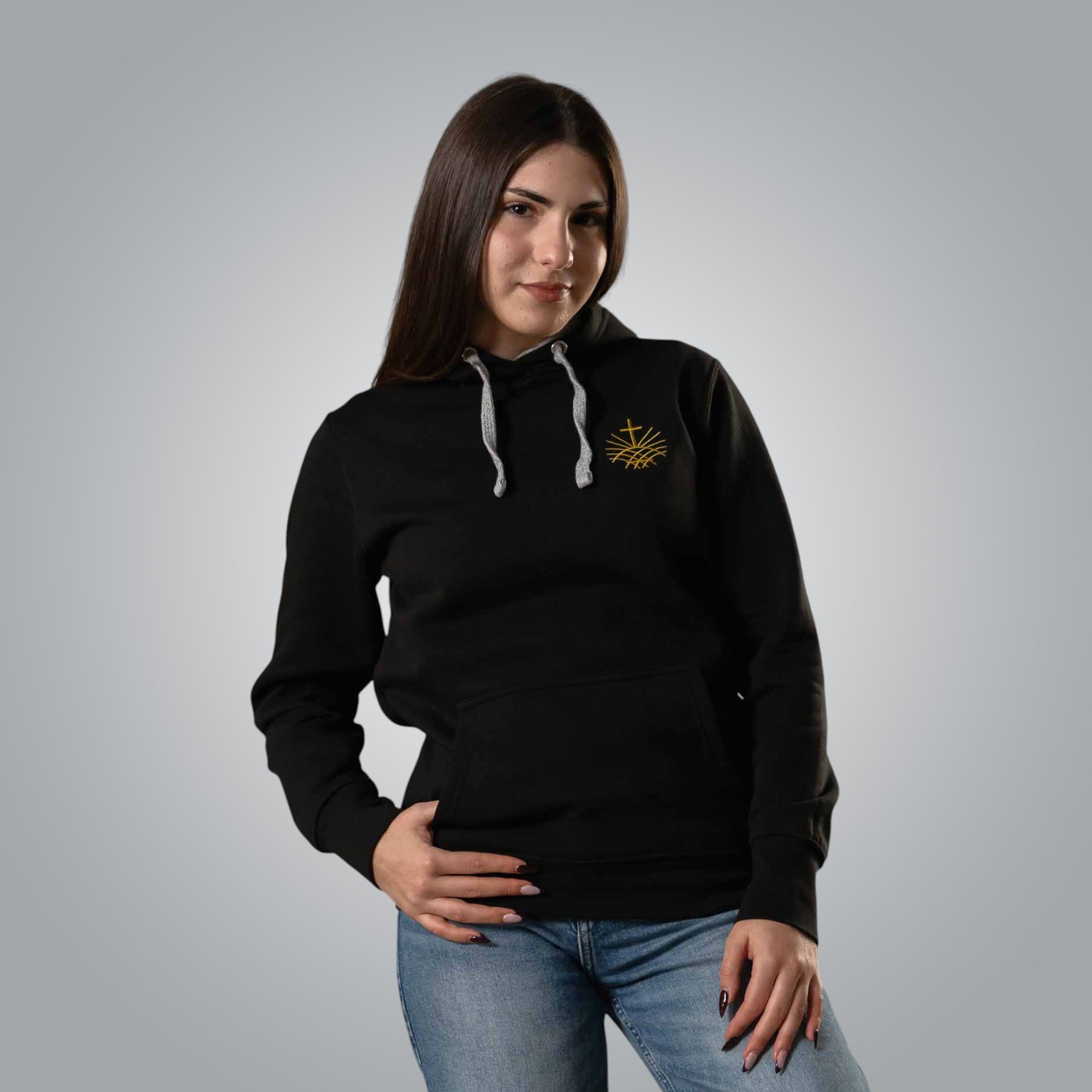 Woman wearing black Christian hoodie with gold embroidered Loom in Light emblem on the chest