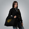 Woman wearing black Christian hoodie with gold embroidery holding Loom in Light tote bag