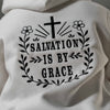 Close up of black embroidered Salvation Is by Grace text on white hoodie