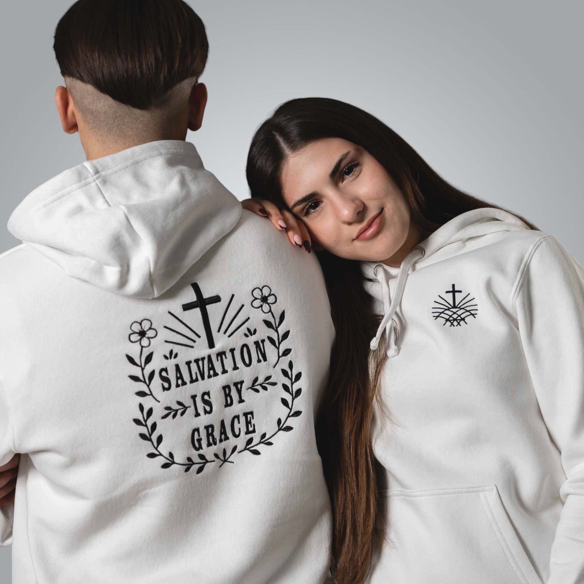 Woman wearing white Christian hoodie standing next to a man wearing the same hoodie