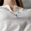 Macro close up of embroidered dove and floral design on white Christian V neck t shirt